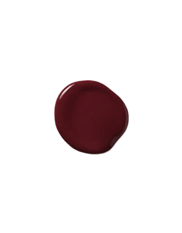 A circular splotch of dark red liquid on a transparent background mirrors the rich hues of the Moroccanoil Color Depositing Mask Bordeaux 6.7 oz.